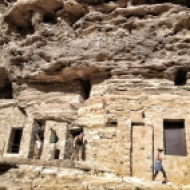 Exterior del complejo arqueológico. Sobre el grupo de tres personas la oquedad de la cueva 6 por donde entra la luz que produce el efecto. LUIS ROCA ARENCIBIA